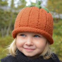 photo d'un enfant portant un bonnet qui ressemble à un potiron