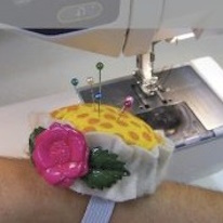 photo d'un pique épingle bague en tissu jaune décoré un bouton en forme de fleur
