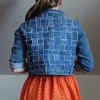 photo d'une personne de dos portant une veste en jean au dos de tissu tissé