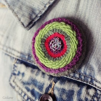 photo d'une broche tissée violette verte et rouge