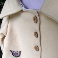 photo de trois boutons en bois sur un manteau blanc