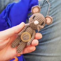 photo d'une peluche souris en crochet, une pièce entre ses bras