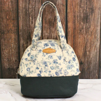 photo d'un sac à main à motif de fleurs bleues et fond bleu foncé