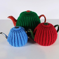 photo de trois théière portant des cache-théière en tricot