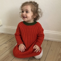 photo d'une enfant portant une robe orange à col vert, comme une citrouille