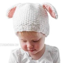 photo dun enfant portant un bonnet blanc avec deux petites oreilles tombantes