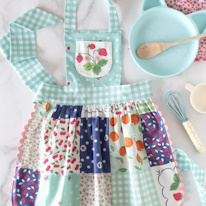photo d'un tablier pour enfant en patchwork à motifs de fruits avec une poche à motif de fraisier