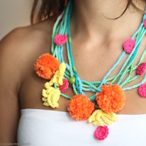 photo d'un collier à pompons et fleurettes en crochet