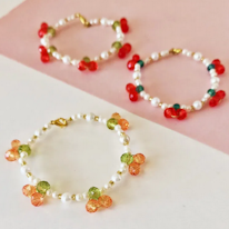 photo de trois bracelets en perles arrangées en paires de cerises