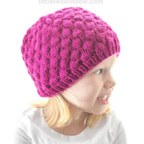 photo d'une enfant portant un bonnet ressemblant une grosse framboise