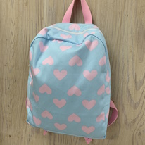 photo d'un sac à dos bleu clair à coeur rose pastel