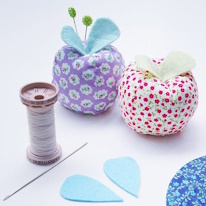 photo de deux pique-épingles en forme de pommes avec de petites feuilles en feutrine