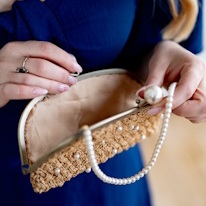 phoot d'un sac en raphia décoré de perles avec un fil de perles en poignée