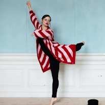 photo d'une adulte dansant vêtue d'un long cardigan à rayures