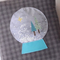 photo d'un coussin décoré d'une poche ronde transparente contenant des sequins libres