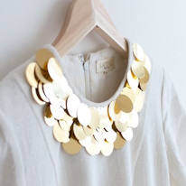 photo d'une robe blanche à l'encolure décorée de sequins dorés