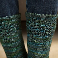 close-up sur la bordure d'une paire de chaussettes vertes décorées de petits arbres