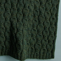 close-up sur un châle vert à motifs de feuilles