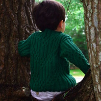 photo d'un enfant portant un pullover vert à torsades
