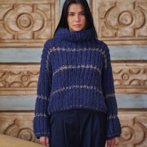 photo d'une adulte portant un pullover bleu à rayures dorées