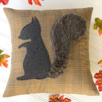 photo d'un coussin à appliqué écureuil dont la queue est en fausse fourrure