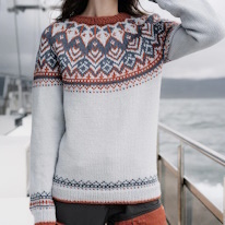 photo d'un lopapeysa blanc à motifs bleus et rouges