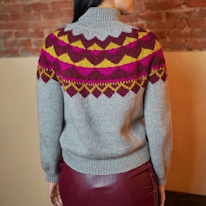 photo d'un lopapeysa gris à motifs roses et jaunes