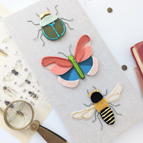 collage en feutrine d'un scarabée, un papillon et une abeille